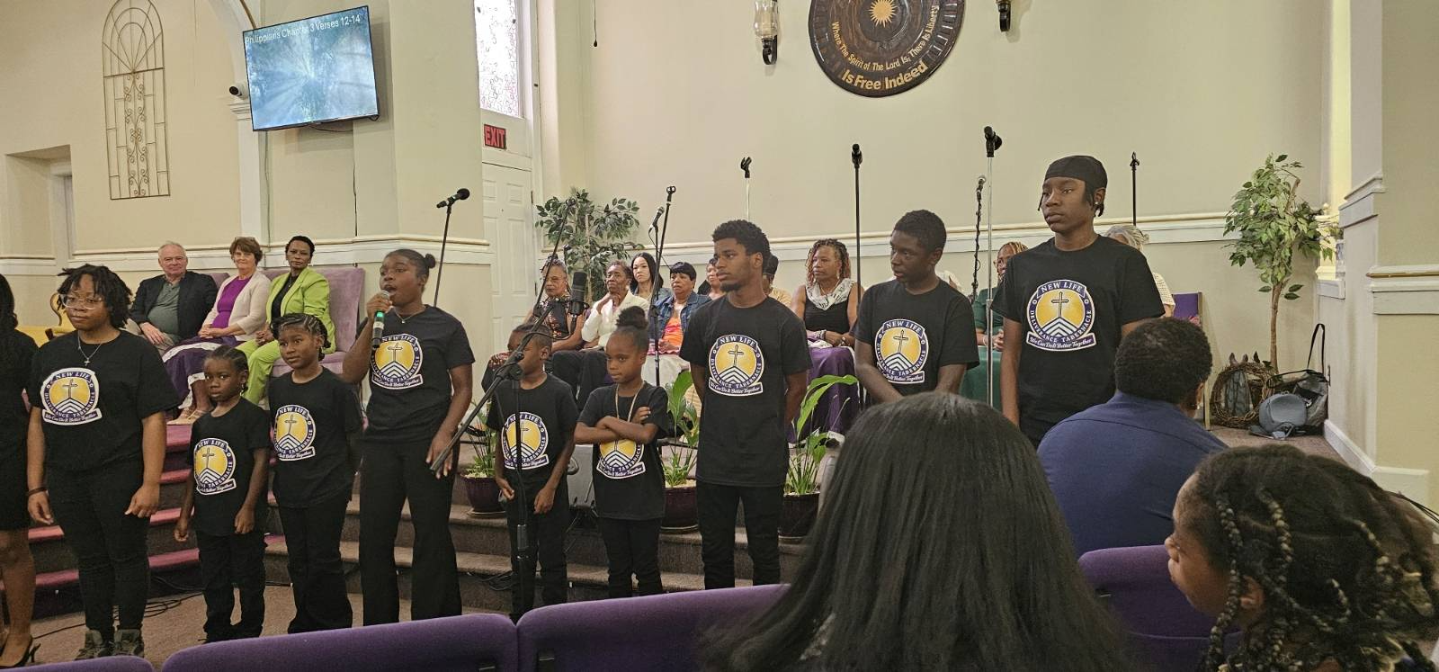 Youth choir in matching custom New Life Deliverance Tabernacle shirts